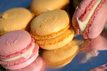 French cake macaron or macaroon at picnic outdoors. Colorful cookies made from almond flour in pastel colors. 