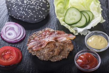 Fototapeta na wymiar Zutaten für einen Hamburger auf schwarzem Schiefer