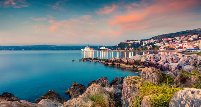 Great evening view of Pilos town. Colorful spring sunset on the Ionian Sea. Beautiful cityscape panorama of Greece city. Traveling concept background. Artistic style post processed photo.