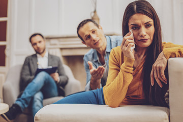 Want to talk with you. Worried male person wrinkling forehead while talking to his wife