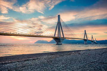 Fototapeta na wymiar Dramatic evening scene with Rion-Antirion Bridge. Colorful spring scene of the Gulf of Corinth, Greece, Europe. Beauty of countryside concept background. Artistic style post processed photo.