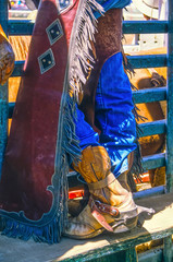 Colse-up of the legs of a cowboy at a rodeo. 