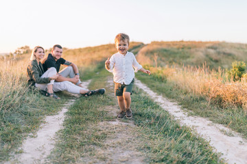 happy parents looking at adorable smiling little son running on trail © LIGHTFIELD STUDIOS