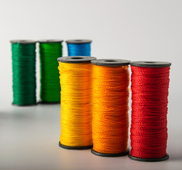 multicolored threads, scissors and ruler, basket. on a light background