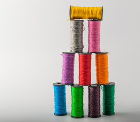 multicolored threads, scissors and ruler, basket. on a light background