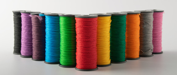 multicolored threads, scissors and ruler, basket. on a light background