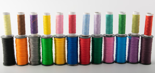 multicolored threads, scissors and ruler, basket. on a light background