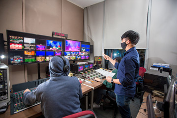 Behind the televised broadcast in the control room, live in the control room. Producer looking at...