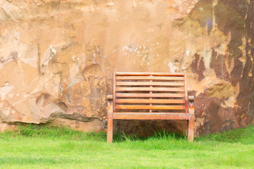 Wooden chair with stone wall on grass