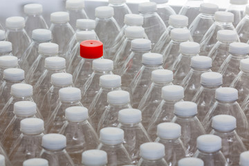 Fototapeta premium Multiple white capped plastic bottles with one red