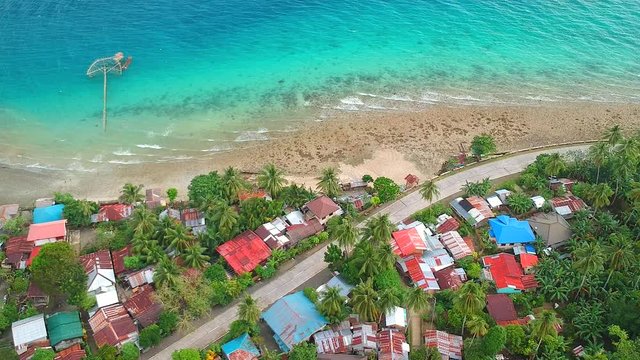 Drone shot of a tropical village in a coastal part of Malitbog, Southern Leyte, Philippines. There used to be a softball field in the brown and green area but as decades go by, the sea level rose.