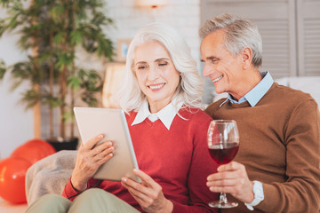 Modern technology. Charming female person expressing positivity while reading article online