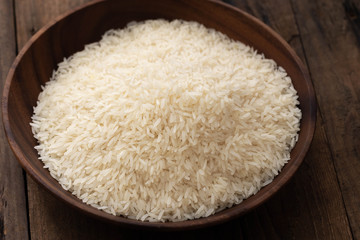 raw rice in wood plate on wood
