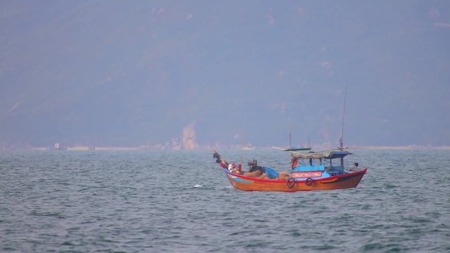 South China Sea, Nha Trang, Central Vietnam, Asia, August 26 2018. Vietnamese fishing boats navigating across the South China Sea, deep sea fishing in wooden boats casting fishing nets.