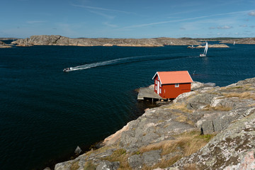 Sea landscape with sailboat and rocky coastline on the South of Sweden. Southern coastline of Sweden with view at sailing-ship and rocky islands.