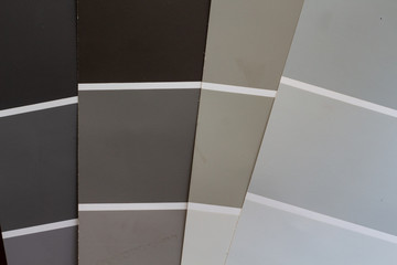 Paint chip samples for redecorating interior or exterior. Deciding on colors. Neutral beige and gray
