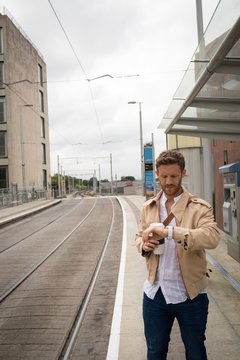 Man checking time on watch in platform