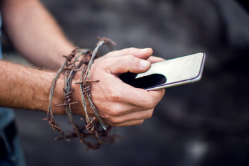 Smartphone with barbed wire on a dark background. Concept of mobile phone addicted.