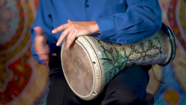 Doumbek drumming slow rhythm with arabic background.