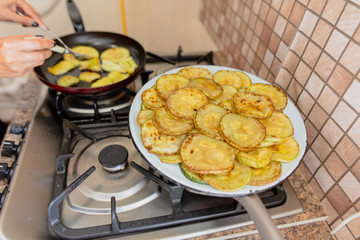 Roast zucchini in the frying pan in the kitchen