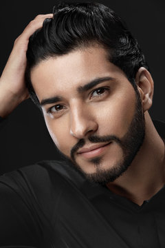 Men Hair Care. Man With Beard Touching Healthy Black Hair
