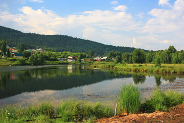 Fototapeta na wymiar The village on the shore of the pond