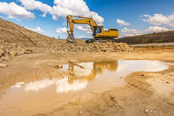 Big excavator moving earth in the construction works of a road