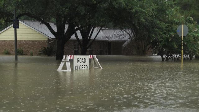 Road closed sign in front of a house during hurricane harvey. Footage was captured during light rain. the water does come halfway up the house.