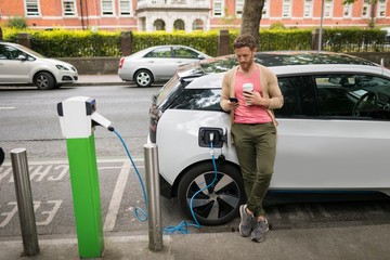 Man using mobile phone at charging station
