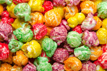Multicolored popcorn scattered on pile. Background, close up.