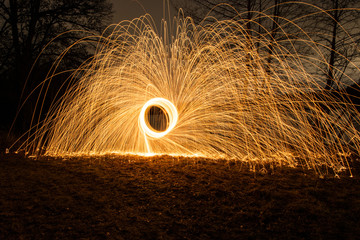 Lightpainting burning steel wool, circle, with flying sparks