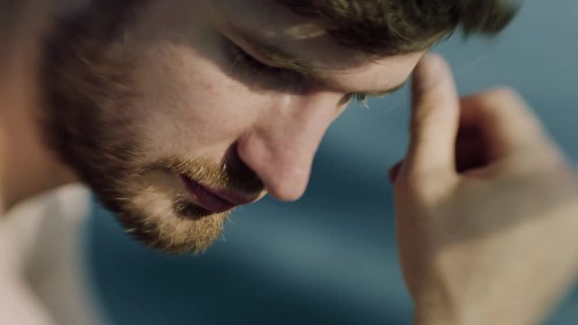 Man in thought against out of focus lake in the sun