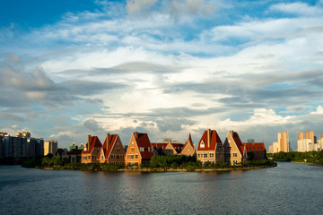 European Designed Cottages on River Bank under Blue Sky