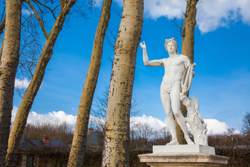 Statue of Apollo with a lyre at the garden of the Versailles Palace in a freezing winter day just...