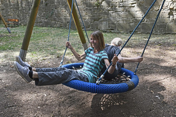 zwei frauen schaukeln auf einem kinderspielplatz