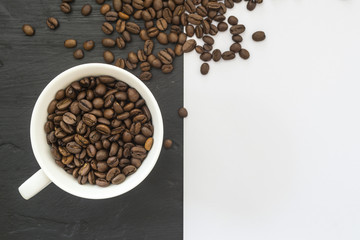 A cup of coffee beans on a black-and-white background. Free place for the inscription.