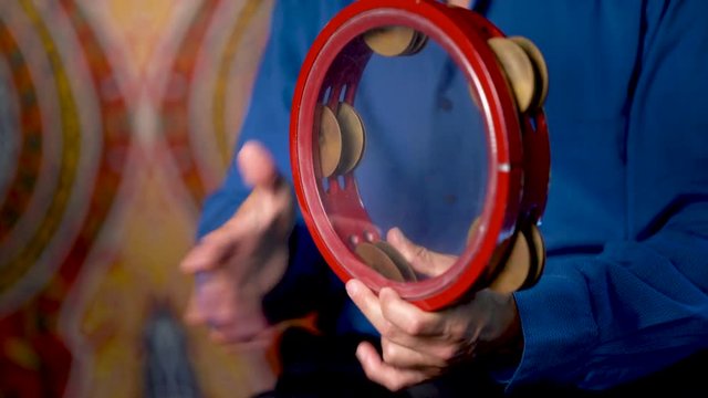 Closeup of hands playing zills and center of drum on clear riq with beladi rhythm.