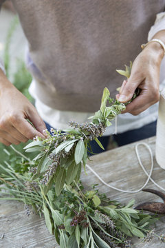Woman making smudge stick with fresh herbs