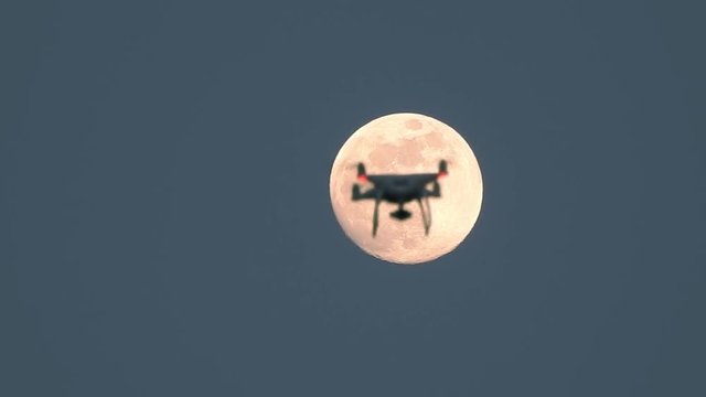 Drone hovering in front of fullmoon