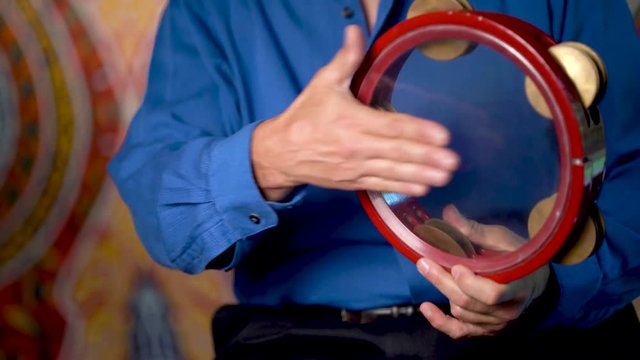 Closeup of hands playing sharp rhythms red clear riq.