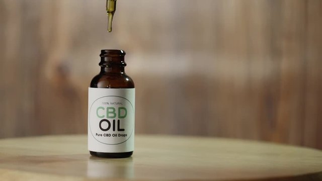 CBD Oil drips into non-branded CBD Oil Bottle
