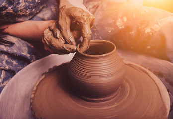 Hands of a potter, creating an earthen jar on the circle