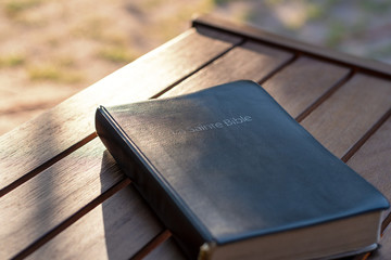 Christian worship and praise. The bible on a chair in the morning light. Text : Holy Bible (in...
