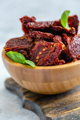 Homemade sun-dried tomatoes and basil in a bowl.