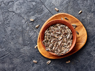 Sunflower seeds on a black bacground. Top view of snacks.