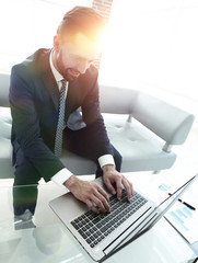 Smiling businessman browsing information on laptop,