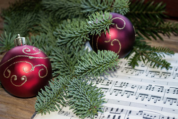 Alte Musiknoten mit roten Weihnachtskugeln und Tannenzweig, Weihnachten, xmas 