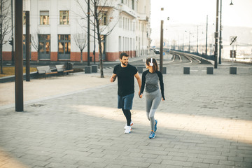 Healthy runners running in city with cityscape in background