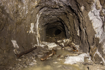 Underground abandoned gold iron ore mine shaft tunnel gallery passage with timbering wooden