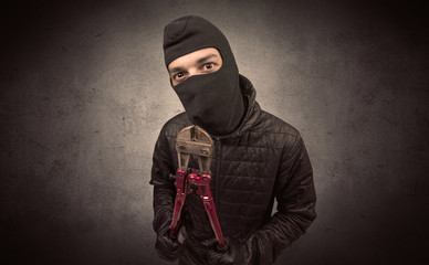 Burglar standing in black clothes and balaclava on his head.